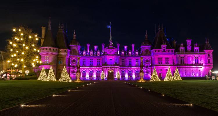 Waddesdon Manor illuminated at night with Christmas trees