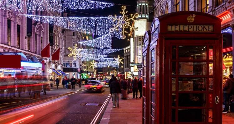 London street with festive holiday lights and iconic red phone booth