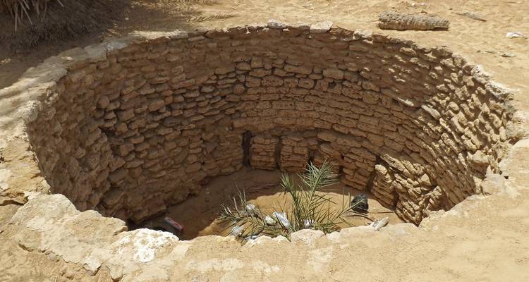 Cirkelvormige stenen structuur ingebed in zand.