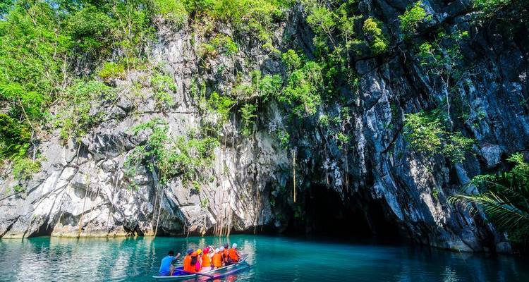 Canoë en groupe dans une grotte entourée d'une végétation luxuriante.