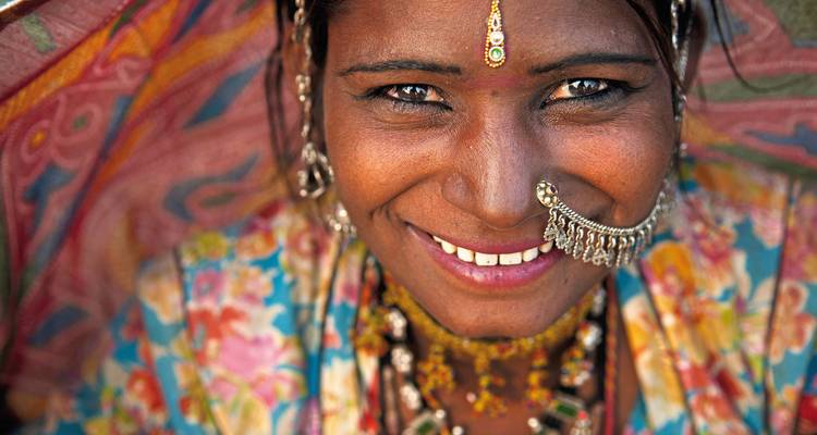 Un portrait en gros plan d'une femme souriante portant une tenue traditionnelle.