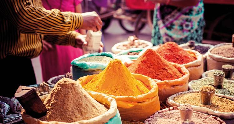 Bags of spices on display at a lively market.