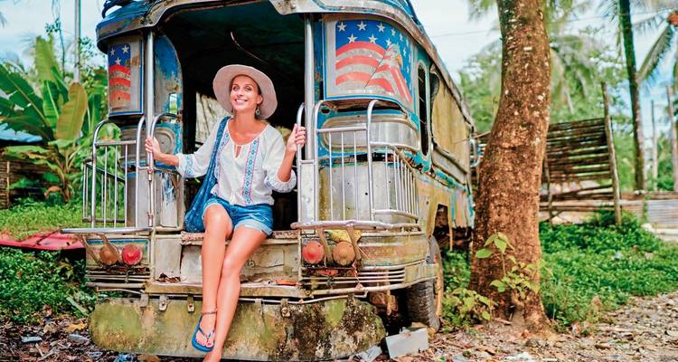 Personne assise sur un jeepney coloré.