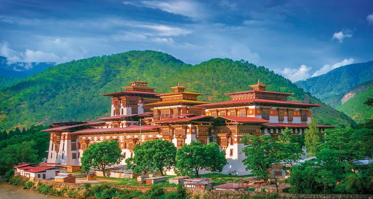 Wunderschöner Dzong umgeben von üppig grünen Bergen in Bhutan.