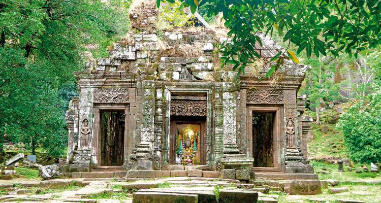 Ancient temple partially covered in vegetation.