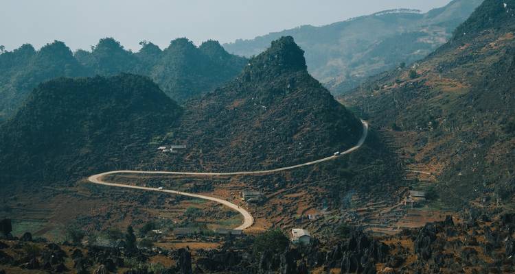 Carretera de montaña remota serpenteando a través de terreno escarpado.
