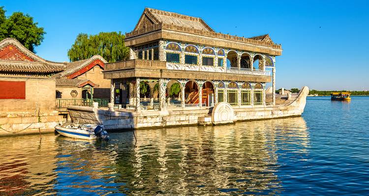 Dekorativer bootsförmiger Pavillon auf einem See.