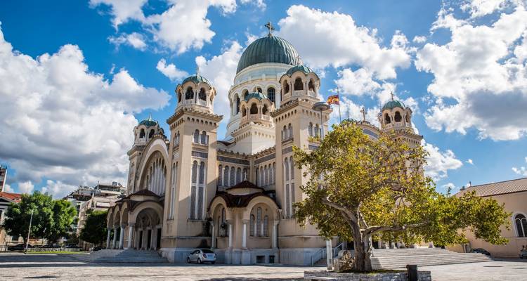Ornate church with a central dome and vibrant tree.