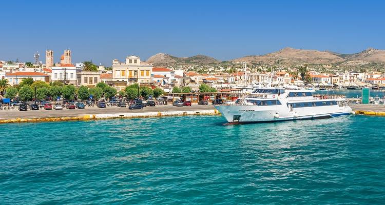 Ferry docked at a vibrant coastal town with clear blue skies.