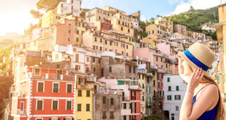 Person observing colorful hillside buildings in a coastal village.