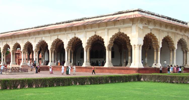 Historisch gebouw met meerdere bogen en mensen die rondlopen.