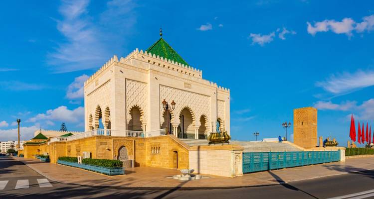 Bâtiment de mausolée avec un toit aux tuiles vertes sous un ciel dégagé.