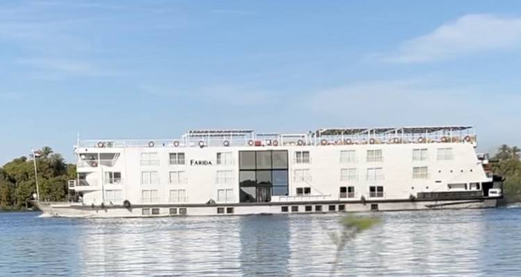 Un bateau de croisière fluviale naviguant sur une rivière calme.