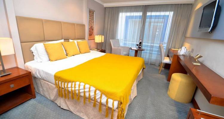 Une chambre d'hôtel bien décorée avec un thème jaune.