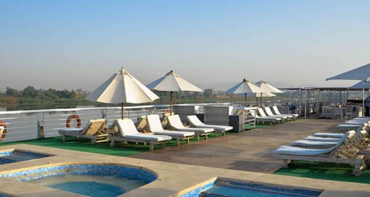 Une terrasse avec des chaises longues et des parasols sur un bateau de croisière fluviale.