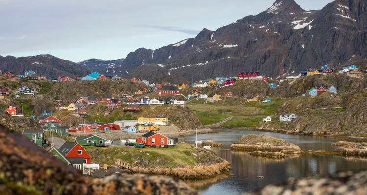 Bunte Häuser in einem malerischen Dorf, umgeben von Bergen.