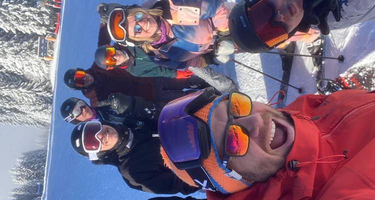 Selfie de groupe joyeux de skieurs portant des lunettes et des casques par une belle journée d'hiver ensoleillée.