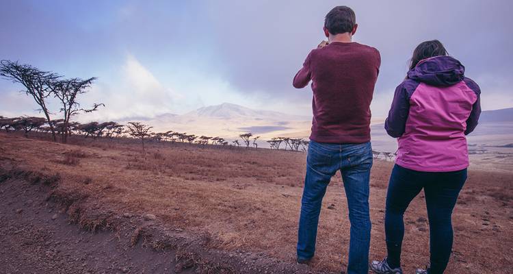 Deux personnes prenant une photo d'un paysage pittoresque avec des montagnes.