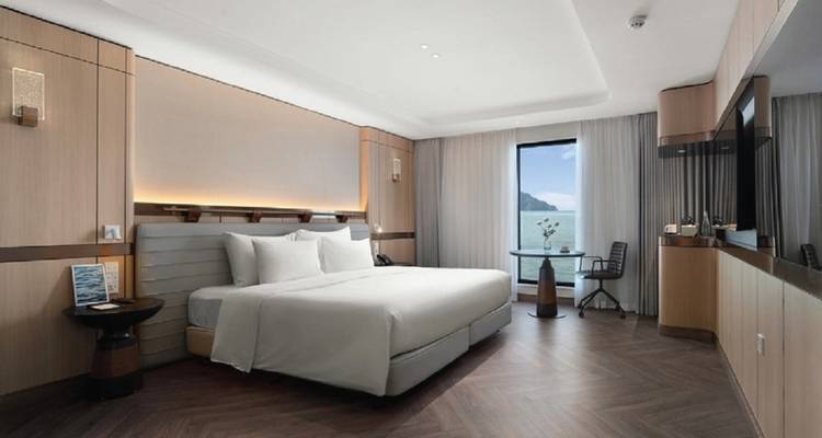 Chambre d'hôtel moderne avec vue sur l'eau depuis la fenêtre.