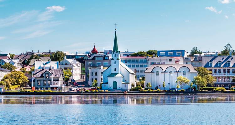 Stadtlandschaft einer Stadt mit einer markanten Kirche am Wasser.