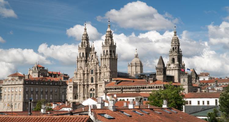 Une cathédrale historique avec de hautes tours sous un ciel partiellement nuageux.