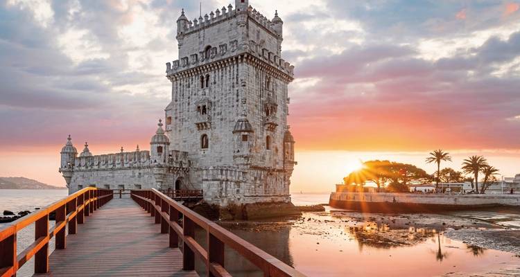 Belem Tower at sunset with a vibrant sky.