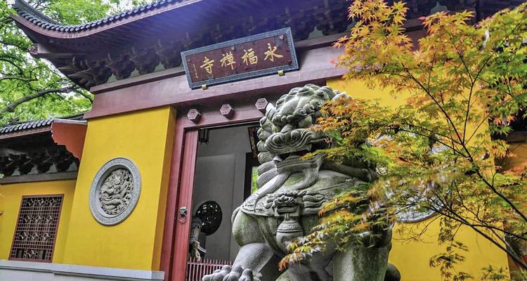 Close-up van een traditionele Chinese tempelpoort met een leeuwenstandbeeld.