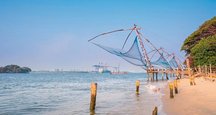 Traditionelle chinesische Fischernetze, die sich über ruhige Küstengewässer unter einem klaren blauen Himmel erstrecken.