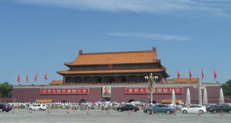 Puerta de Tiananmen with retrato de Mao enmarcado por muros rojos, banderas ondeando y multitudes reunidas en la plaza.