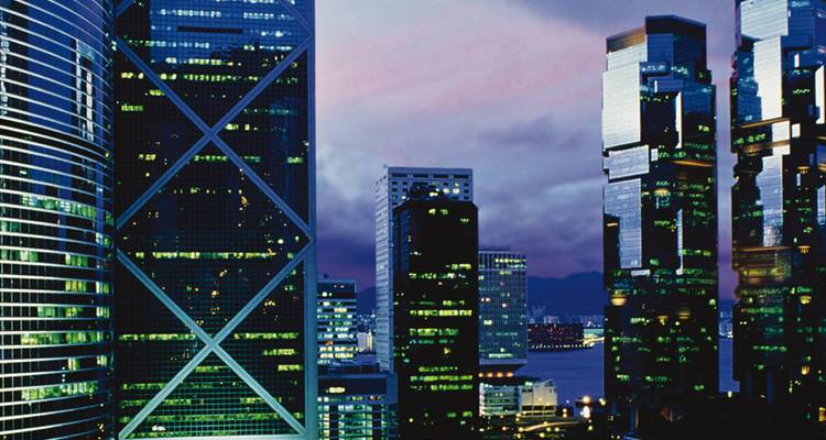 Wolkenkratzer in Hongkong mit lebendigen Stadtlichtern in der Dämmerung.