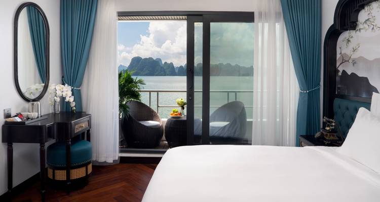 Chambre d'hôtes luxueuse avec balcon donnant sur une baie pittoresque.