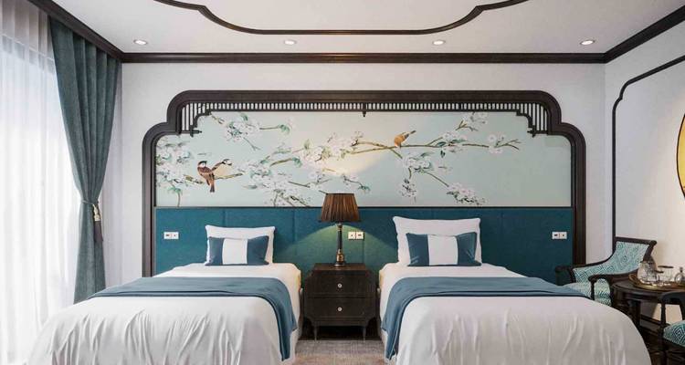 Chambre à deux lits jumeaux décorée avec goût sur un thème inspiré de la nature.