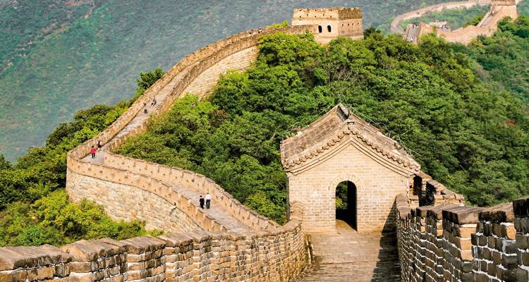 Iconic section of the Great Wall of China with hills and greenery.