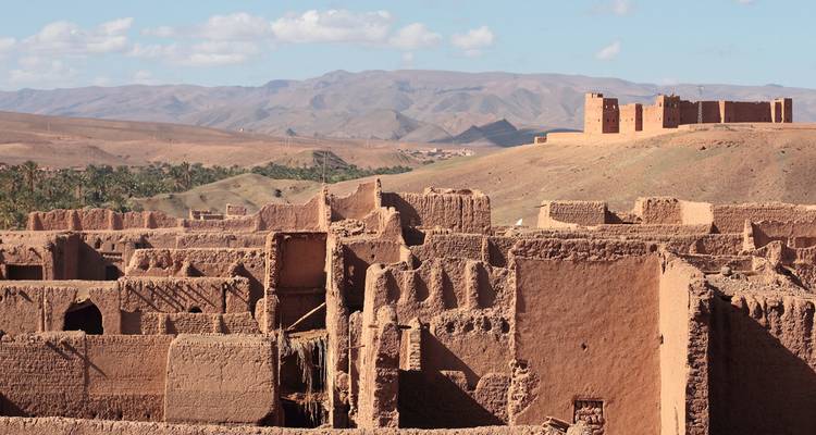 Vista expansiva de edificios de adobe deteriorados dispersos en una árida meseta desértica.