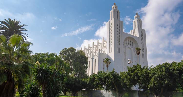 Vue d'une grande église blanche se détachant sur un ciel bleu.
