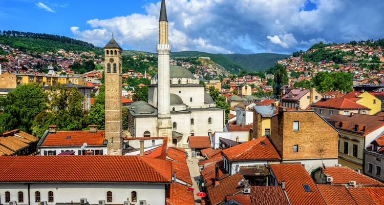 Tejados de Sarajevo con minaretes y colinas.