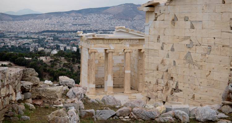 Ruines d'architecture grecque antique surplombant une ville.