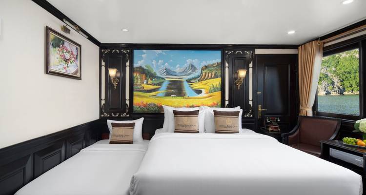 Luxueuze hotelkamer met schilderijen en uitzicht op water door de ramen.