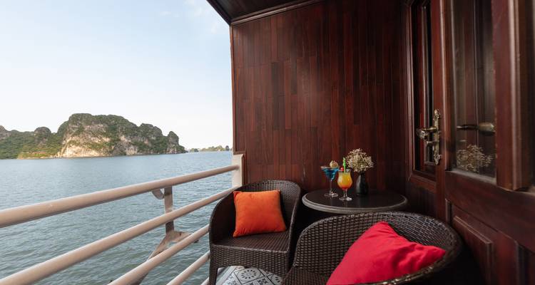 Balcony view with two chairs facing the water and mountains.