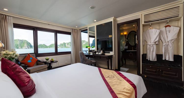 Luxurious hotel room with a view of water and mountains.