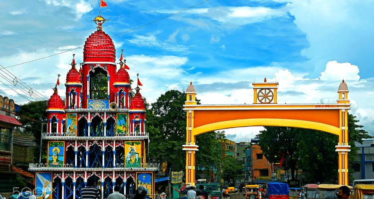 Colorful gate and temple with Hindu deities in a street setting.