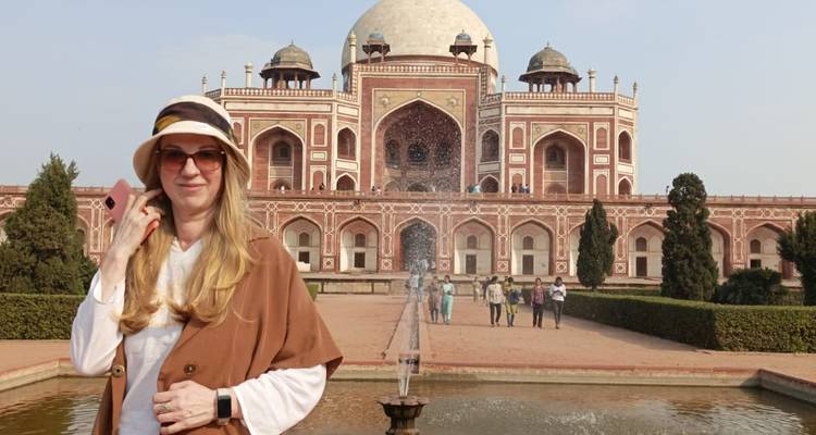 Woman in front of grand historic tomb.