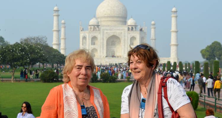 Two women in garden with Taj Mahal.