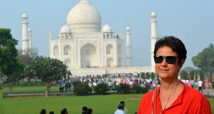A woman in sunglasses standing in front of the Taj Mahal.