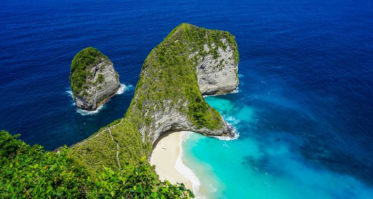 Dramatische Klippe und geschwungener weißer Sandstrand von Kelingking an einem lebhaften türkisfarbenen Meer.