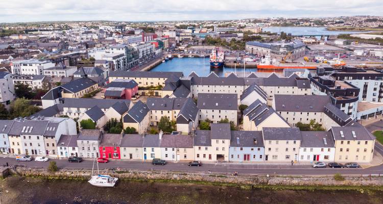 Luftaufnahme einer Stadt mit bunten Häusern und einem Hafen.
