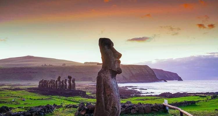 Moai beelden op Paaseiland bij zonsondergang met uitzicht op de oceaan.