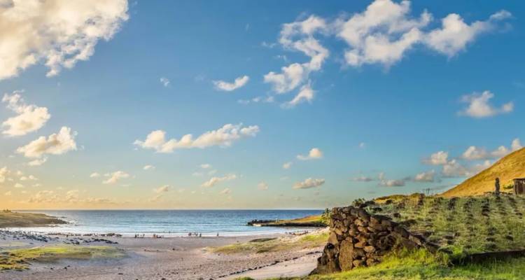 Peaceful sandy cove and rolling grasslands meeting the Pacific Ocean at Easter Island