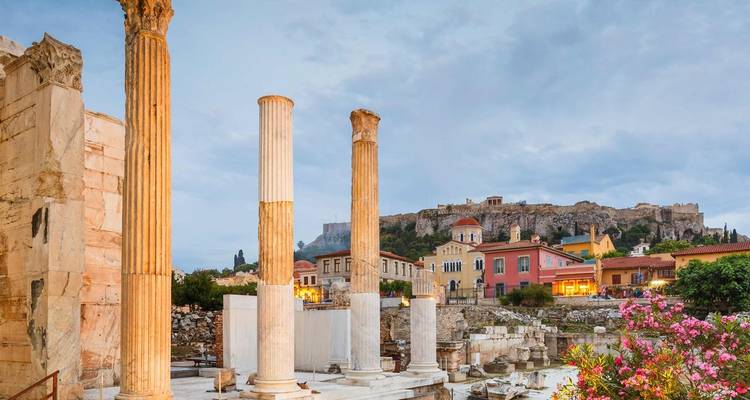 Antike Ruinen mit Säulen und Stadtlandschaft im Hintergrund.
