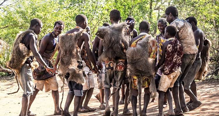 Gruppe von Menschen in traditioneller Kleidung, die im Kreis tanzen.